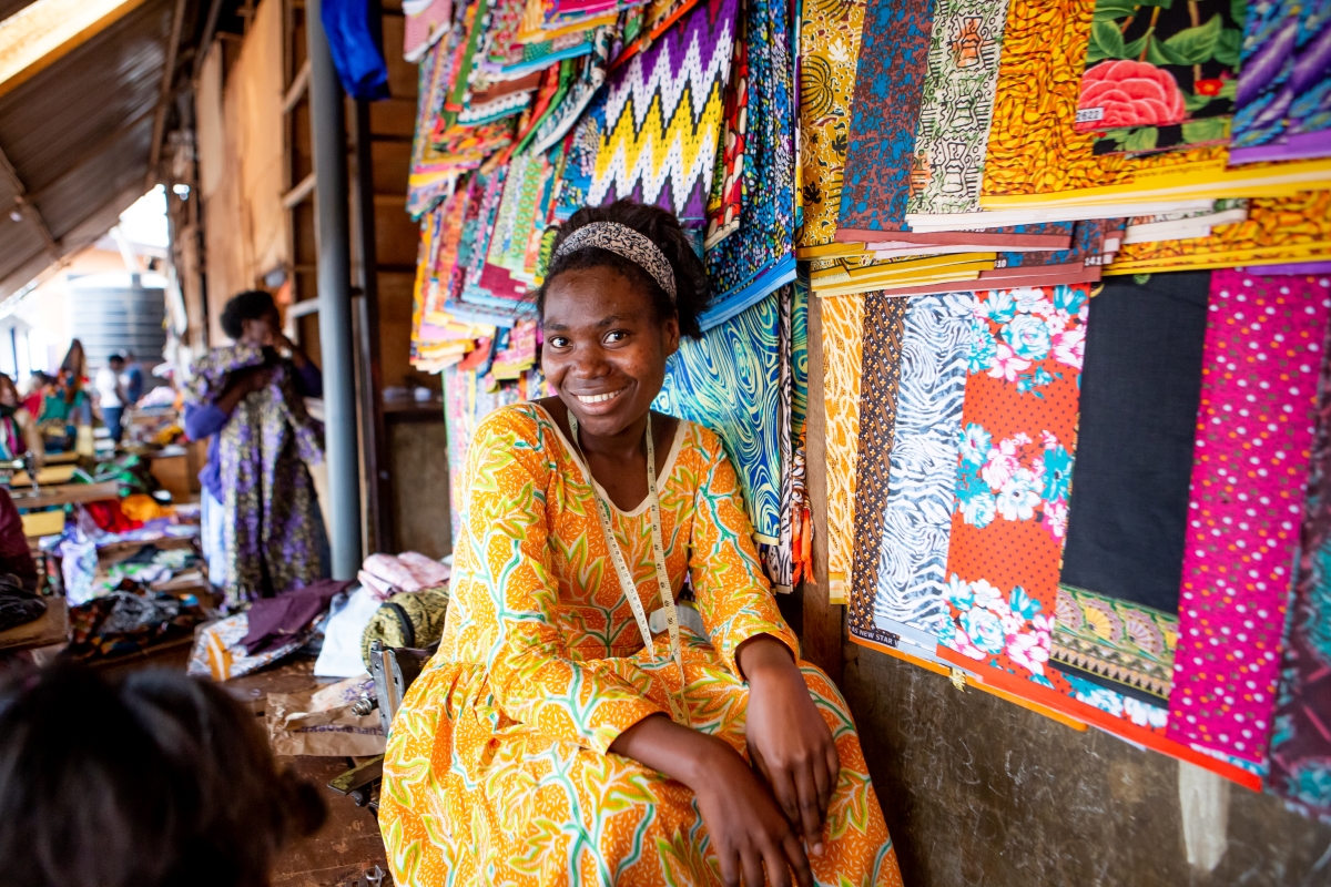 Singita-Kwitonda-Lodge-Volcanoes-National-Park-Rwanda Rwandan woman smiling in front of her textile stall