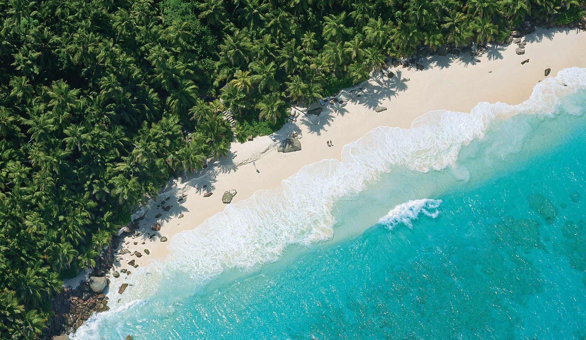 beautiful-blue-beaches-seychelles Aerial view of Seychelles showing turquoise ocean, white beaches, and lush forest